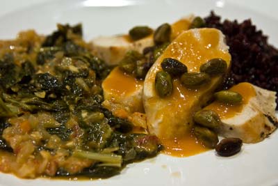 Plated collards with rice and chicken and braised pistachios